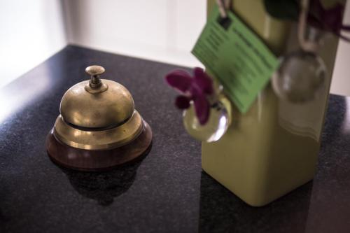 una pequeña campana sentada en un mostrador junto a una nevera en Le Bannier Hotel Restaurant en Orléans