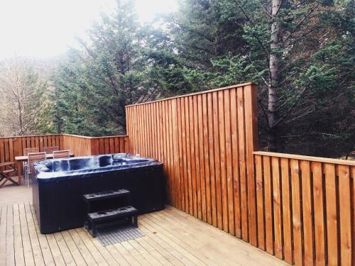 a hot tub on a deck with a wooden fence at Bard Cottage in Akranes