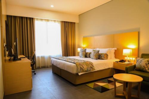 una camera d'albergo con letto e divano di Ayla Ibri Hotel a Ibri