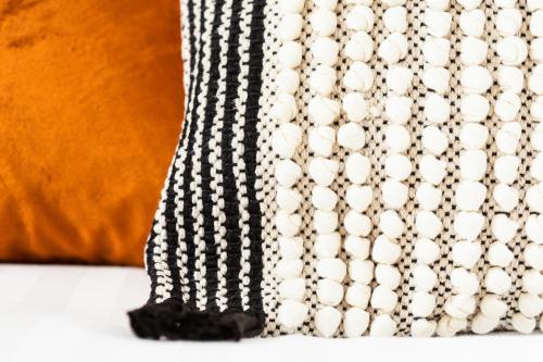 a black and white curtain with a orange pillow at The Snug Townhouse in Galway
