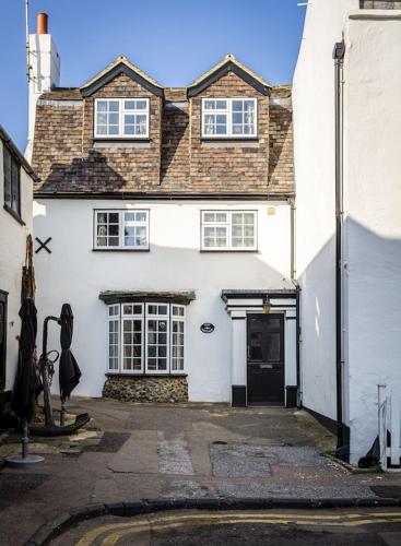 a white house with a black door on a street at Bay Cottage in Broadstairs - Exclusive unmissable deals! Book now before it's too late! in Broadstairs