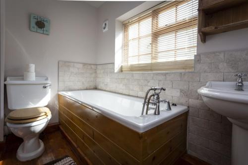 La salle de bains est pourvue d'une baignoire, de toilettes et d'un lavabo. dans l'établissement Bay Cottage By The Sea in Broadstairs., à Broadstairs