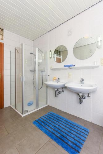 a bathroom with two sinks and a shower at Ferienhaus Elfriede Coordes in Moorweg