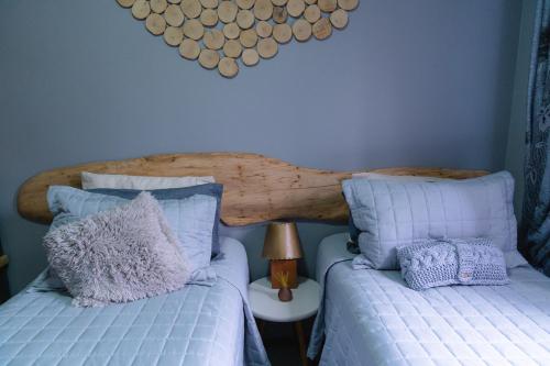 a bedroom with two beds and a wooden headboard at Refúgio dos Coiotes in Cambara do Sul