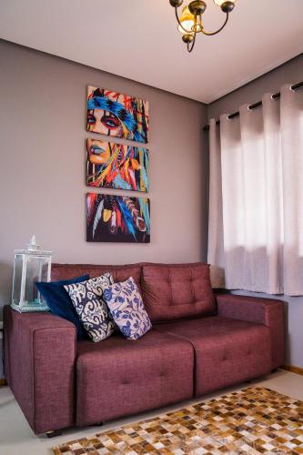 a couch in a living room with a painting on the wall at Refúgio dos Coiotes in Cambara do Sul