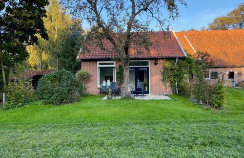 a small brick house with an orange roof at Vakantiehuisje op de Rotmanshoeve in Kotten