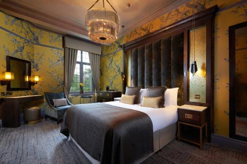 a bedroom with a large bed and a chandelier at Aldwark Manor Estate in Aldwark