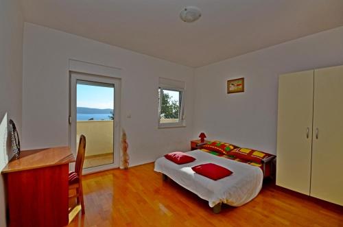 - une chambre avec un lit, un bureau et une fenêtre dans l'établissement Apartment in Kastel Sucurac with sea view, balcony, air conditioning, WiFi 570-3, à Kaštela