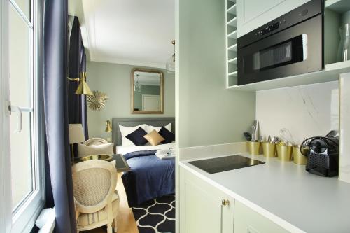 a small room with a kitchen and a bedroom at Studio Opéra by Studio prestige in Paris