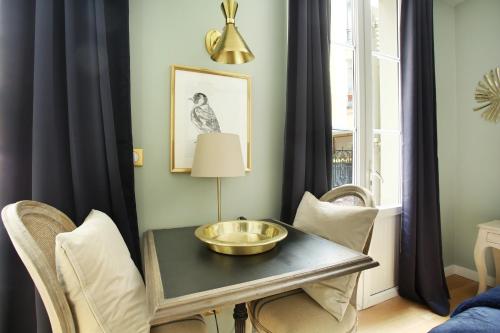 uma sala de jantar com uma mesa com uma tigela de ouro em Studio Opéra by Studio prestige em Paris