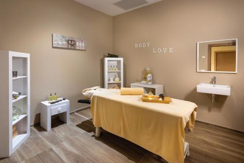 a small room with a bed and a sink at Hotel Riu Paraiso Lanzarote - All Inclusive in Puerto del Carmen