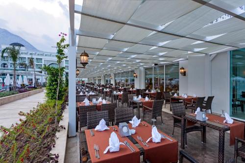 凯麦尔Karmir Resort & Spa - Ultra All Inclusive的餐厅配有桌椅,位于山脉的背景中