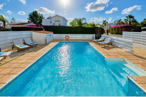 a swimming pool with two chairs and a swimming pool at Villa Crystal by Ezoria Villas in Coral Bay