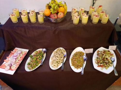 a table topped with plates of food and bowls of fruit at Seven Corbett in Rāmnagar