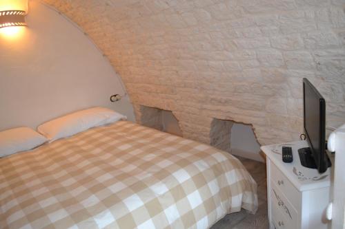 a bedroom with a bed and a flat screen tv at Conversa De Amicis n°8 in Alberobello