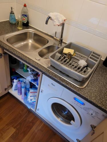 a kitchen with a sink and a washing machine at The Rampling's in Crawley