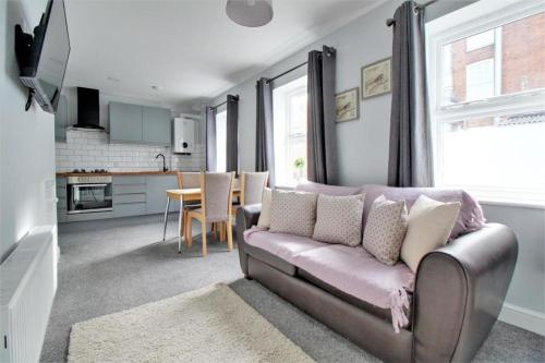 a living room with a couch and a kitchen at Nelson By The Docks Serviced Apartments by Roomsbooked in Gloucester