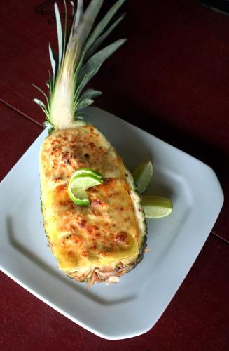 a pineapple sitting on a white plate on a table at Vila Itaqui in Luis Correia
