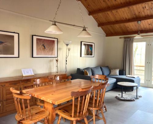 a living room with a wooden table and a couch at Familie Meys Chalets - Chalet 249 - La Boverie in Rendeux