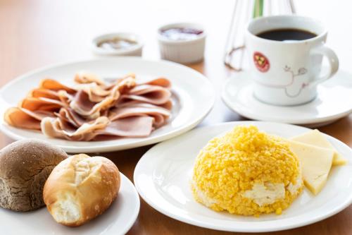 a table with plates of food and a cup of coffee at Vidam Hotel Aracaju - Transamerica Collection in Aracaju