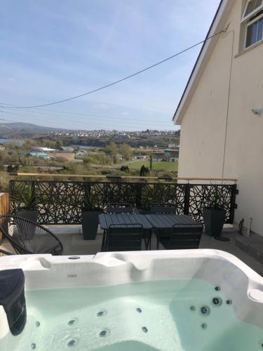 a jacuzzi tub on the balcony of a house at Artro House in Pembrokeshire