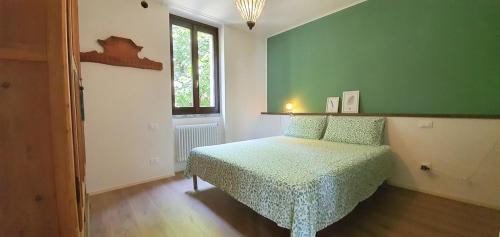 sypialnia z łóżkiem i zieloną ścianą w obiekcie Appartamento Montebello w mieście Rovato