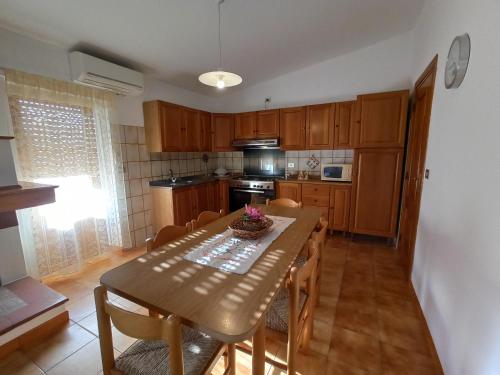 een keuken met een houten tafel en een eetkamer bij Casa Saba Lupino in Orosei