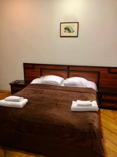 a bedroom with a bed with two towels on it at CATTALEYA in Batumi