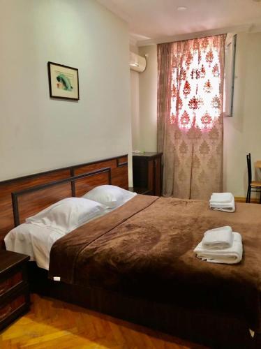 a bedroom with a bed with two towels on it at CATTALEYA in Batumi