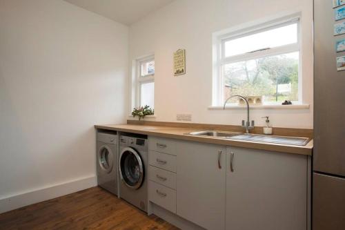 a kitchen with a sink and a washing machine at Rie's Retreat - The Whole House in Glastonbury