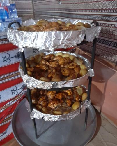 two trays of food on top of a glass table at Bedouin host camp& with tour in Wadi Rum
