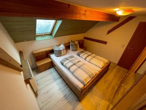 Cama grande en habitación con ventana en Ferienwohnung Heuboden, en Amtzell