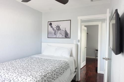 a white bedroom with a bed and a tv at Best Home To Visit NYC+Hot Tub+EWR Airport+Free Parking in Hillside