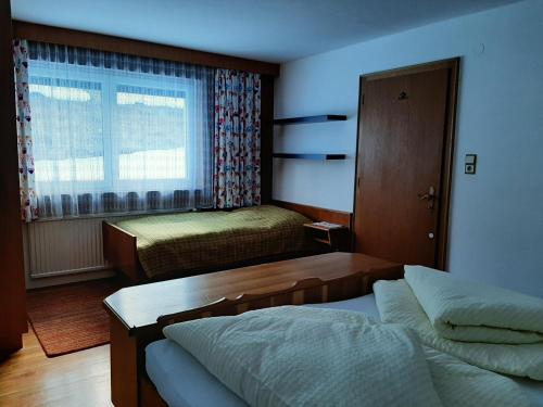 Cette petite chambre comprend 2 lits et une fenêtre. dans l'établissement Apartment Michaeli, à Pettneu am Arlberg