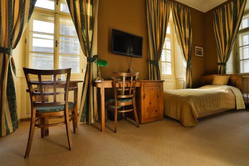 a bedroom with a bed and a desk and two chairs at U Schnellu in Prague