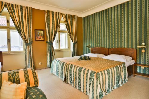 a hotel room with two beds and a chair at U Schnellu in Prague