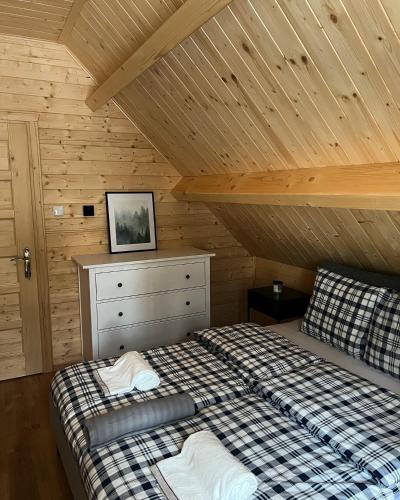 a bedroom with a bed and a wooden ceiling at Aparthouse Siemiany in Siemiany