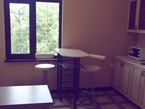 a kitchen with a table and stools in a room at Диас in Sukhum