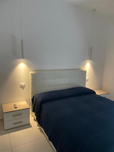 a bedroom with a blue bed and a night stand at Malù B&B in Cimitile