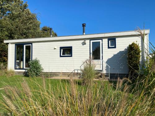 a small white house in the middle of a field at Chalet ZWIN & ZEE Cadzand-Retranchement in Retranchement
