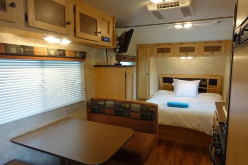 a bedroom with a bed and a table in a trailer at Best RV-Studio to Visit NYC-EWR Airport-Free Parking in Hillside
