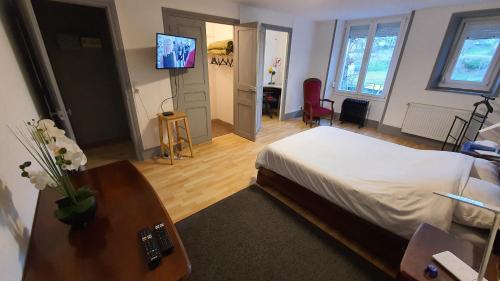 une chambre avec un lit et une télévision sur un mur dans l'établissement Le nid d hirondelles - Terrasse Jardin Grand garage, à Langres