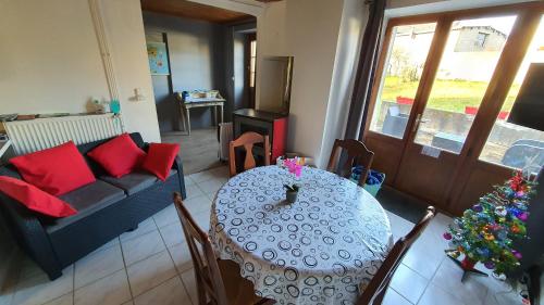 a living room with a table and a couch at Le nid d hirondelles - Terrasse Jardin Grand garage in Langres