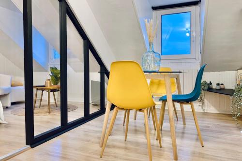 a dining room with yellow chairs and a table at #CM Studio hypercentre in Grenoble