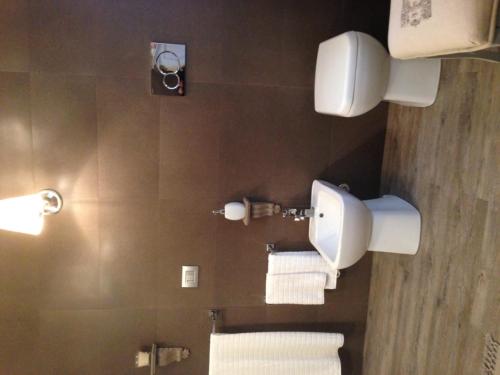 a bathroom with a toilet and towels on the wall at Il Pioppo Antico in Viggiù