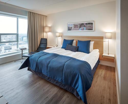 a hotel room with a large bed and a large window at Crowne Plaza Copenhagen Towers, an IHG Hotel in Copenhagen