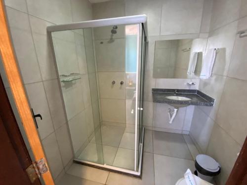 a shower with a glass door in a bathroom at Mirante dos Corais in Porto De Galinhas