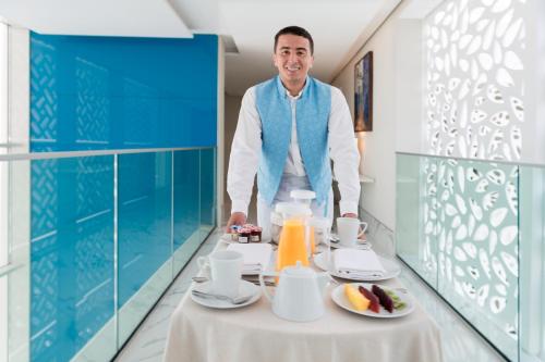 a man standing in a room with a table with food on it at Marchica Lagoon Resort in Nador