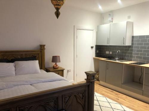 een slaapkamer met een bed en een keuken met een wastafel bij Frederick property Apartment in Birmingham