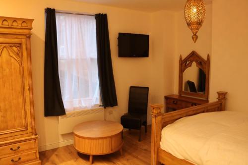 een slaapkamer met een bed, een stoel en een raam bij Frederick property Apartment in Birmingham